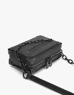 Meet your new go-to accessory: the Crossbody Box Bag with Attached Chain Detail, where style meets practicality.

Crafted with an edgy mix of textures and a thoughtfully designed pattern, this bag is made for those who appreciate a touch of moody sophistication. The exterior boasts a durable, grainy finish complemented by a bold chain detail, offering a juxtaposition of nonchalance and polish. Inside, the bag features a neatly organized compartment with a dedicated space to secure your essential Chic Rectangular Box Bag With Chain, Trendy Rectangular Shoulder Bag With Hardware, Elegant Rectangular Bag With Hardware Details, Rectangular Box Bag With Chain Strap For Travel, Modern Clutch Box Bag With Chain Strap, Rectangular Box Bag With Chain, Rectangular Chain Box Bag, Modern Crossbody Box Bag With Chain Strap, Modern Box Bag With Chain Strap