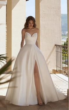 a woman in a white wedding dress standing on a porch with her legs crossed and wearing high heels