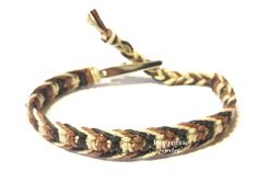 a braided bracelet with metal clasps on it's end and a white background