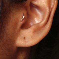 a woman's ear is shown with a small gold nose pin in the middle