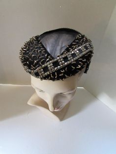 SALE! 10% OFF! Fantastic vintage cocktail hat by Woodmere New York.  The body of the hat is in black velvet.  It is liberally decorated with faceted copper tone beads forming grid like squares as angling bands which outline the very center of the crown --a triangular shape open except for its fine net cover. Scattered small copper tone beads form little peaks throughout the crown. The hat is anchored by 2" long side angled prongs outlined in copper beads. . The hat is lined in brocade where the Vintage High Crown Fascinator For Party, Retro Black Costume Hats And Headpieces For Party, Vintage Costume Hat With Pinched Crown For Party, Vintage Costume Hats With Structured Crown For Party, Vintage Structured Crown Fascinator For Party, Beaded Party Costume Hats And Headpieces, Vintage Hat With Structured Crown For Parties, Vintage High Crown Mini Hat For Parties, Vintage Structured Crown Headpiece For Party