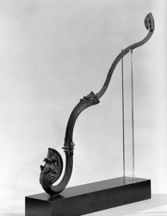 an old fashioned sculpture is on display with a glass holder and metal rod attached to it