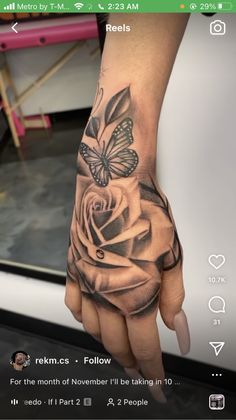 a person's hand with a tattoo on it and a butterfly flying over the rose