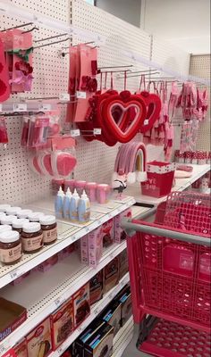 there are many items on the shelves in this store that is pink and red with hearts hanging from them