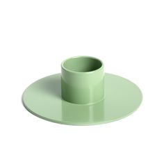 a green cup sitting on top of a plate