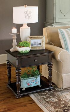 a living room with a couch, table and lamp on it's end table