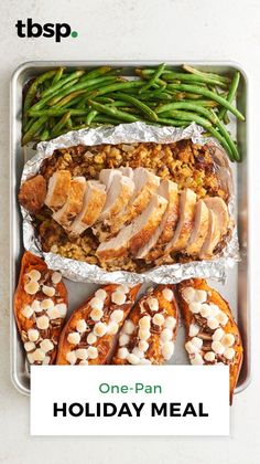 a tray filled with turkey, green beans and other food items on top of it