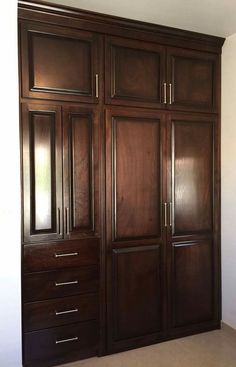 a large wooden closet with many drawers and doors