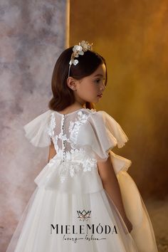 The Lily Dewdrop couture flower girl and communion dress is a masterpiece of elegance and whimsy, perfect for any special occasion. Its fitted bodice, adorned with hand-stitched lace appliqués, pairs beautifully with a sweetheart neckline and flutter sleeves, creating a charming and delicate look. The floor-length, full circle multilayered princess skirt features two levels of luxurious tulle and lace for added volume and grace. Made from the finest European lace, satin, and lattice pattern tulle fabrics, this gown boasts an elegant ballroom silhouette with a lace-embellished long train. Available in two enchanting color options—ivory with cappuccino highlights or pure ivory—the dress is fully lined for comfort and protection. The zipper and buttons closure at the back ensures a secure and First Communion Party, Voluminous Skirt, Communion Party, First Communion Dress, Tulle Sleeves, Luxury Flowers, Straight Skirt, Flower Girl Dress, Floral Applique