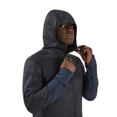 a man in a hooded jacket is adjusting his hood