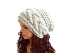 a woman wearing a white knitted hat on top of a mannequin head