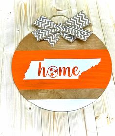 a wooden sign with the word home painted on it and a bow in the middle