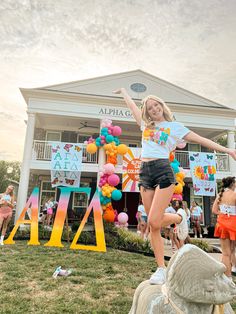 a girl is jumping in the air with her arms outstretched and balloons all around her