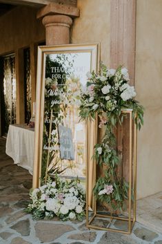 a photo frame with flowers and greenery on it next to a sign that says thank you