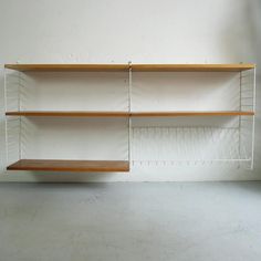 two wooden shelves sitting next to each other on top of a white wall and floor