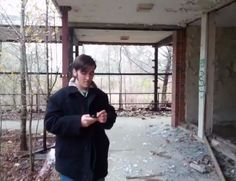 a young man standing in an abandoned building