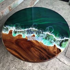 a glass table with the letter j painted on it and waves crashing in to shore