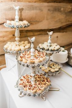 three tiered trays filled with cupcakes on top of a white table