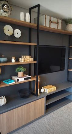 an entertainment center with shelves, vases and other items on the wall behind it