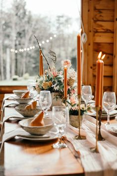 a wooden table topped with plates and glasses