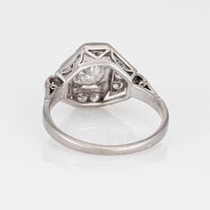 an antique style diamond ring with three diamonds on the sides and a center stone in the middle