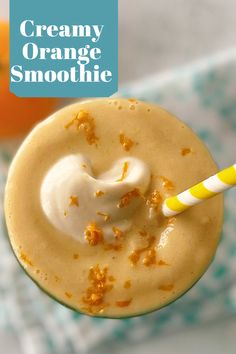 an orange smoothie in a glass with a yellow and white straw