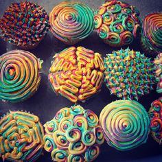 many colorful cupcakes are arranged on a plate