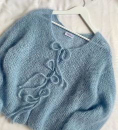 a blue sweater is hanging on a hanger