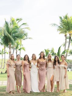 a group of women standing next to each other on top of a grass covered field