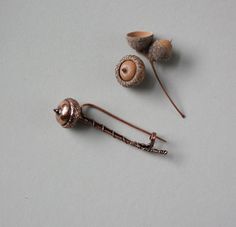 Add a touch of nature-inspired charm to your wardrobe with this unique real acorn copper branch brooch. This versatile accessory can be used as a sweater pin or a shawl pin, adding a whimsical and rustic flair to any outfit. Copper Brooch, Copper Work, Sweater Pin, Leaves Illustration, Shawl Pin, Jewelry Brooch, Shawl Pins, Fall Jewelry, Wire Art