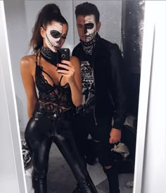 a man and woman with makeup on taking a selfie in a mirror together wearing black leather pants