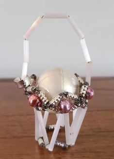 a white beaded object sitting on top of a wooden table