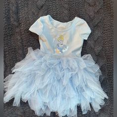 Beautiful Silky Blue Cinderella Dress With Tulle. Top Of The Dress Is Super Soft And Stretchy, Contrast Silver Glitter Band Where Tulle Starts. Really Full Tulle Skirt With Silky Liner Plus Attached Bodysuit Underneath. Nwot Size 2t Blue Cinderella Dress, Cinderella Dress, Dress With Tulle, Full Tulle Skirt, Tulle Top, Disney Cinderella, Cinderella Dresses, Disney Dresses, Pajama Shirt