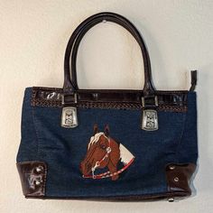 Cleto Western Blue Denim Handbag With Embroidered Horse Head Nwt Looks Like The Bag Had Been Exposed To Moisture. The Fabric Is In Mint Condition And Still Smells New. The Tags Are Wrinkled And Partially Stuck Closed. The Metal Hardware Has Some Slight Discoloration. Please Check Out All The Pictures Carefully, Before Buying, To Ensure A Positive Purchase Experience. All Of Our Items Listed Are Packed Up With Care And Shipped Out From A Clean Smoke Free Environment, By A Collector. All Reasonabl Denim Handbag, Embroidered Horse, Denim Handbags, Horse Head, Metal Hardware, Mint Condition, Blue Denim, Bag Lady, Mint