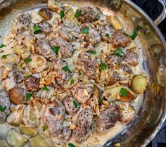 a pan filled with meat and vegetables covered in sauce