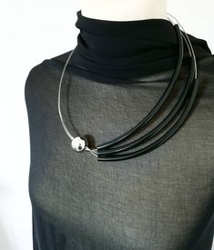 "Fabulous contemporary asymmetrical necklace made of rubber plastic tube, steel wire string cord and silver acrylic bead. The length of the necklace is 58cm (22.8\"). A must have accessory to jazz up your wardrobe. Package will be shipped out as soon as I possibly can which is usually 3 - 5 business day after the purchase. Don't hesitate to contact me if you have any question. Thanks for stopping by and don't forget to check my other items. Join Pevalek Jewellery at https://www.facebook.com/Peva Asymmetrical Jewelry, Black Necklace Statement, Asymmetrical Necklace, Popular Bracelets, Unusual Necklace, Mesh Necklace, Contemporary Necklace, Modern Necklace, Modern Bracelets