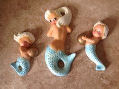 three little mermaid figurines are laying on the floor next to eachother