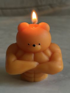 a candle that is shaped like a teddy bear with its arms crossed in front of it