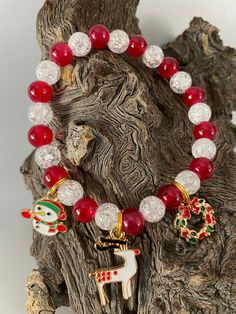 Beautiful handmade Holiday Christmas Beaded Bracelet with Clear Crackle Beads and Solid Red Beads. Charms include Snowman, Reindeer & Christmas Wreath. Charms are attached to split rings (like your car keys) so they can't fall off Beaded Jewelry For Christmas Holiday, Holiday Bracelets With Round Beads, Holiday Adjustable Beaded Jewelry, Adjustable Colorful Beaded Bracelets For Christmas, Adjustable Beaded Stretch Bracelet For Christmas, Christmas Bracelets With Colorful Beads, Christmas Gift Bracelets With Colorful Beads, Christmas Gift Beaded Bracelets With Round Beads, Christmas Holiday Beaded Bracelets With Colorful Beads