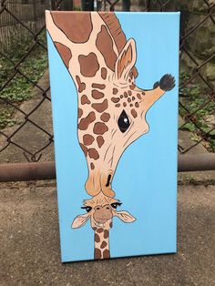 a painting of a giraffe is shown on a blue background behind a chain link fence