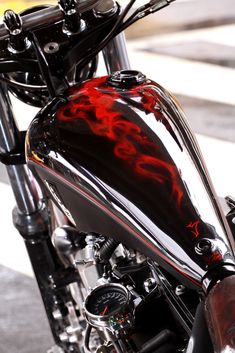 a motorcycle with red flames painted on it's front fenders and the handlebars