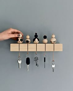 a person is holding keys on a key rack