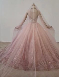 a wedding dress on display in front of a white wall