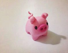 a pink toy pig sitting on top of a table