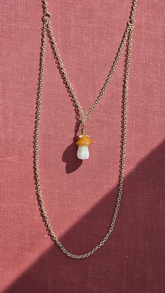 Micro mini blown glass mushroom in amber brown with white spots nested in a layered gold chain.  Mushroom height: ~1.5 cm (0.5 in) Inner chain length: ~ 35 cm ( 14 in) Mushroom Necklace, Layered Chain, Amber Brown, Glass Mushrooms, Layered Chains, Micro Mini, Blown Glass, Chain Lengths, Chain Length