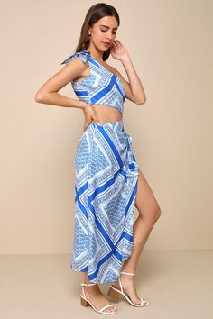 The Lulus Vacay Beauty Blue Scarf Print One-Shoulder Tie-Strap Midi Dress is ready for seaside dinners and late night drinks! Sleek woven satin, with a blue scarf-inspired print throughout, shapes a tying one-shoulder neckline and a darted bodice. A wrapping side cutout accents the fitted waist that tops an asymmetrical column skirt, with an overlapping panel that ties at the side to form a sarong-style effect. Chic midi hem completes the look! Hidden zipper/clasp at side. Fit: This garment fits true to size. Length: Mid-calf length. Size medium measures 43" from adjustable straps to hem. Bust: Great for any cup size. Waist: Fitted - very fitted at natural waist. Hip: Loosely Fitted. Undergarments: May be worn with a strapless bra, adhesive bra, petals, or no bra. Fabric: Fabric has no str Late Night Drinks, Seaside Dinner, Sarong Style, Column Skirt, Satin Scarf, Adhesive Bra, Blue Scarf, Cutout Dress, Strapless Bra