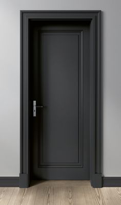 an empty room with a black door and wood flooring on one side, gray walls in the background