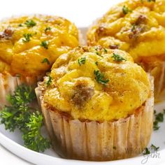 three muffins on a white plate with parsley