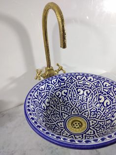 a blue and white bowl sink sitting on top of a counter next to a faucet