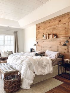 an instagram photo of a bed in a bedroom with white linens and wooden headboard